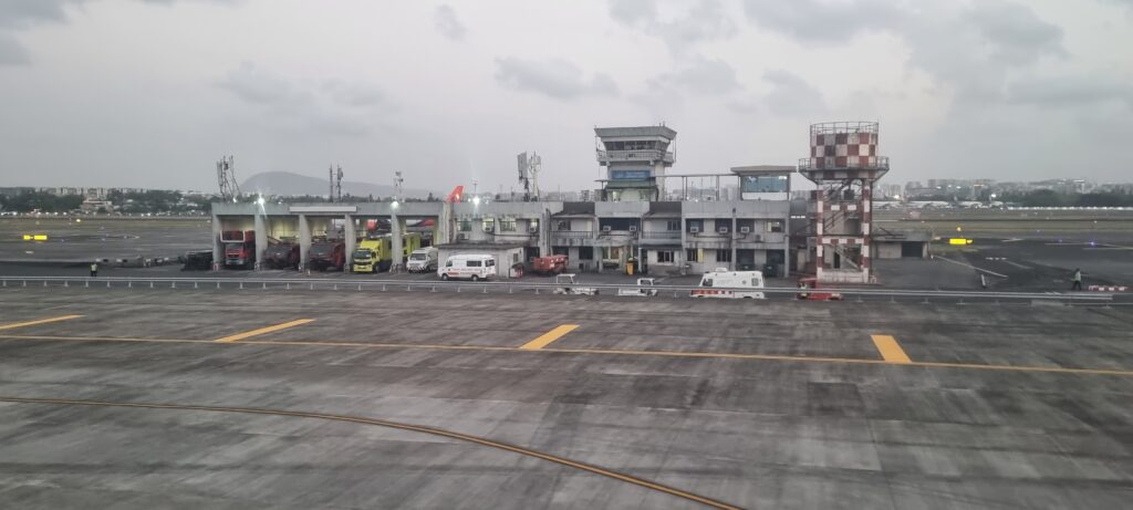 a large airport with a lot of vehicles parked in front of it airport architecture