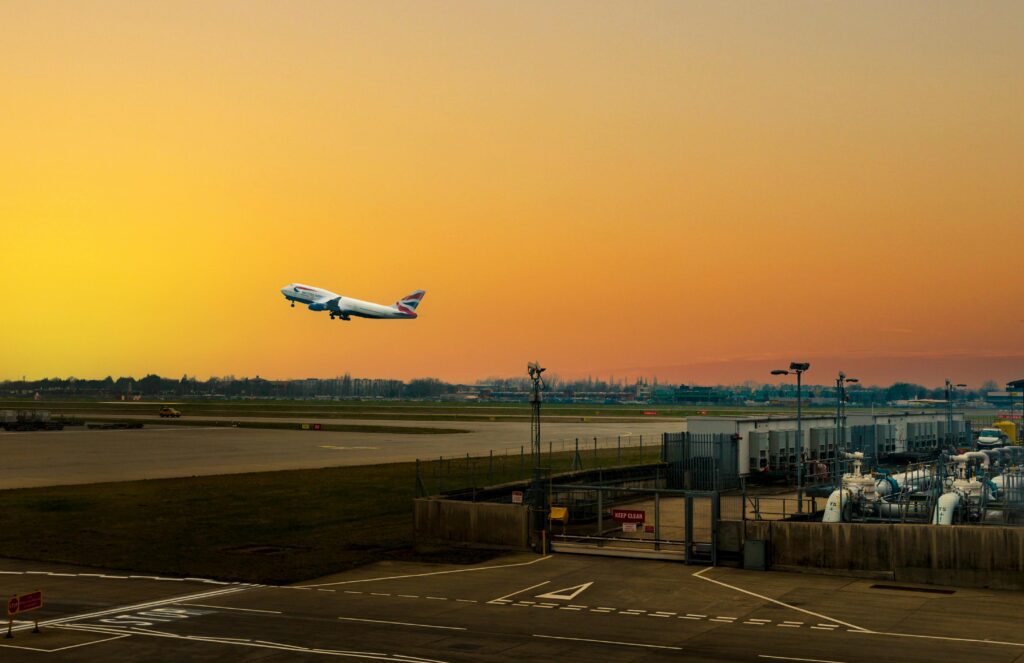 an airplane flying over a runway British Airways Heathrow departures