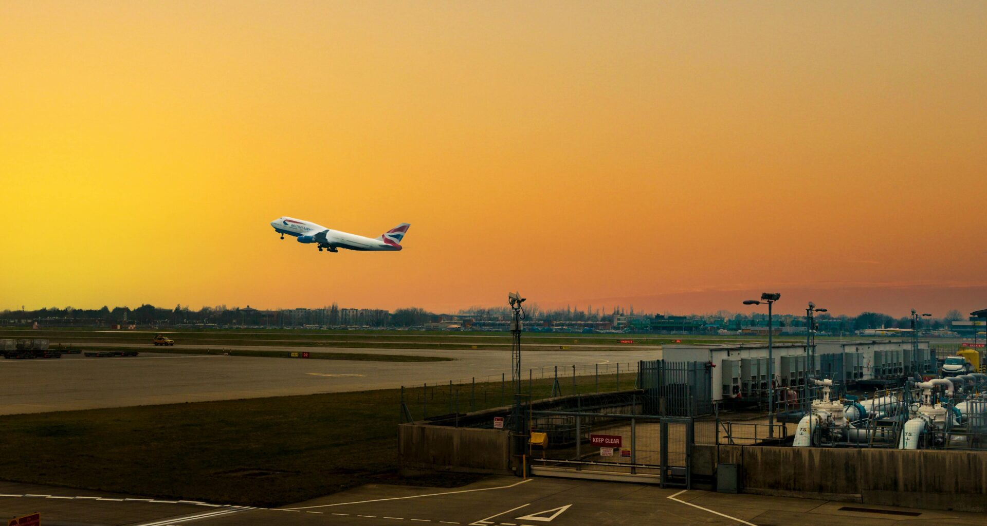 an airplane flying over a runway British Airways Heathrow departures