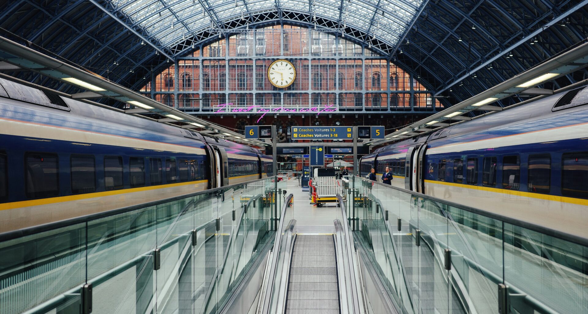 a train station with escalators and a clock with St Pancras railway station in the background Club Eurostar sale