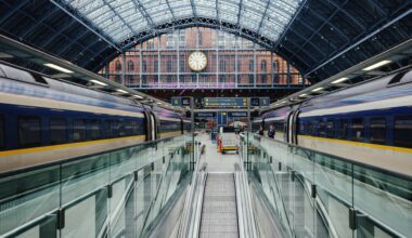 a train station with escalators and a clock with St Pancras railway station in the background Club Eurostar