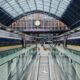 a train station with escalators and a clock with St Pancras railway station in the background Club Eurostar