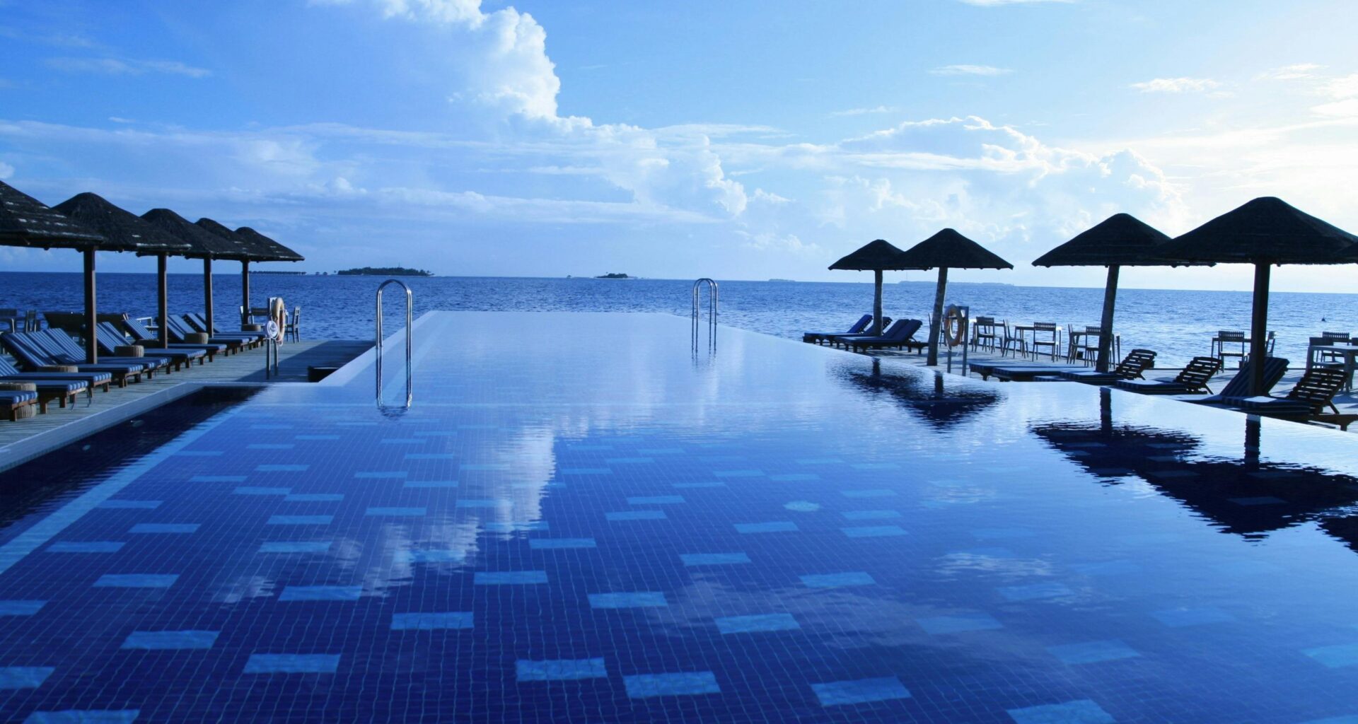 a pool with umbrellas and chairs on the side Virgin Atlantic Credit card