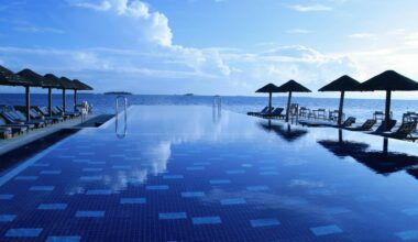 a pool with umbrellas and chairs on the side Virgin Atlantic Credit card