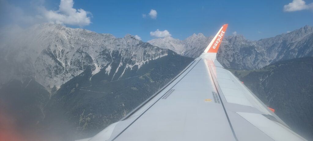an airplane wing with mountains in the background Ryanair Spirit easyJet