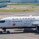 a white airplane on a runway Air Canada London India