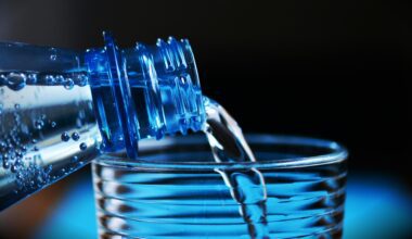a close up of a bottle pouring water into a glass British Airways bottled water