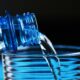a close up of a bottle pouring water into a glass British Airways bottled water