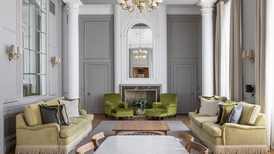 a living room with a fireplace and green couches Edinburgh Marriott Hotel