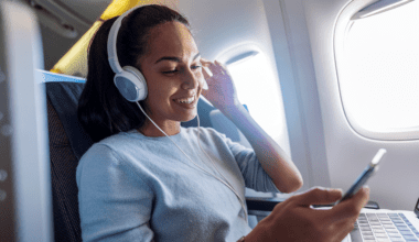 a woman wearing headphones and smiling Priority pass TrvlWell