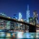 a bridge over water with city skyline at night Virgin Hotels New York