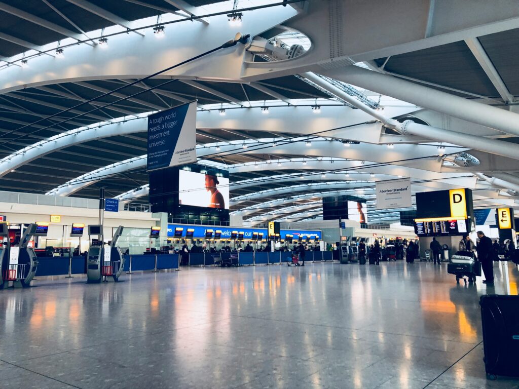 a large airport terminal with people walking around Heathrow Fast Track Arrivals