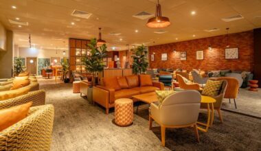 a room with furniture and a brick wall No1 Lounge Heathrow T3