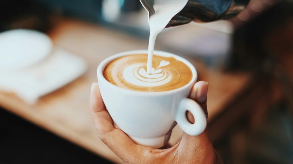 a person holding a cup of coffee Complimentary coffee in hotels